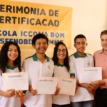 Alunos da Escola Técnica Dom José Maria Pires recebendo certificados na oficina técnicas secretariais Cendac com orgulho, em ambiente escolar iluminado.
