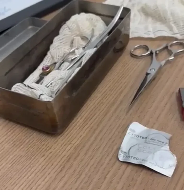 Interior de um sótão insalubre em farmácia, com cama, substâncias e documentos encontrados pela polícia.