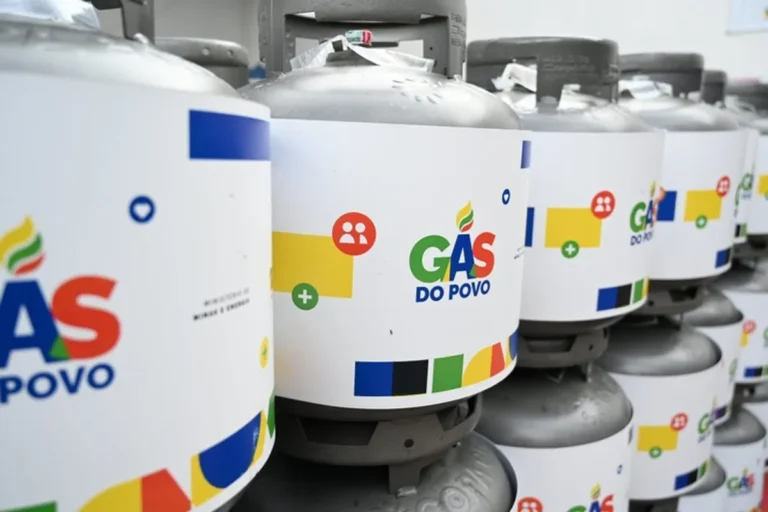 Mulher recebendo botijão de gás do programa Gás do Povo.