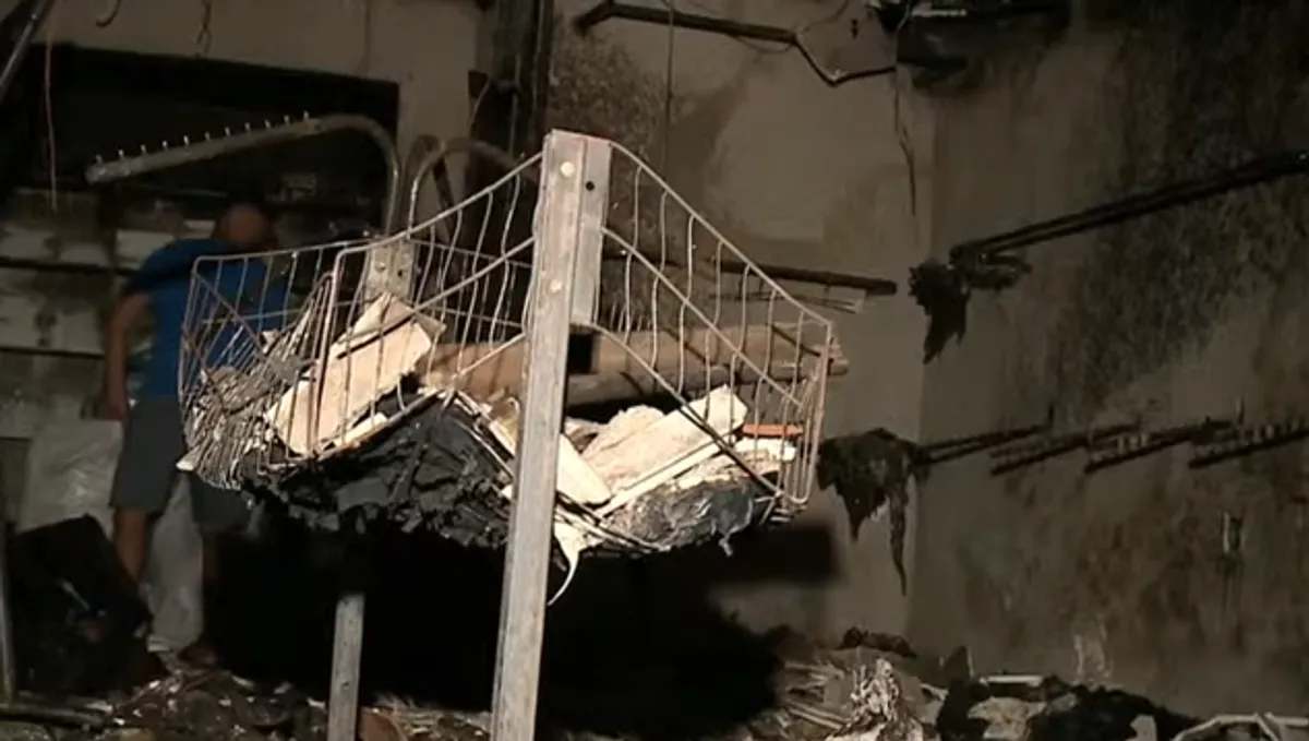 Incêndio em loja de roupas em João Pessoa com fumaça e bombeiros combatendo as chamas.