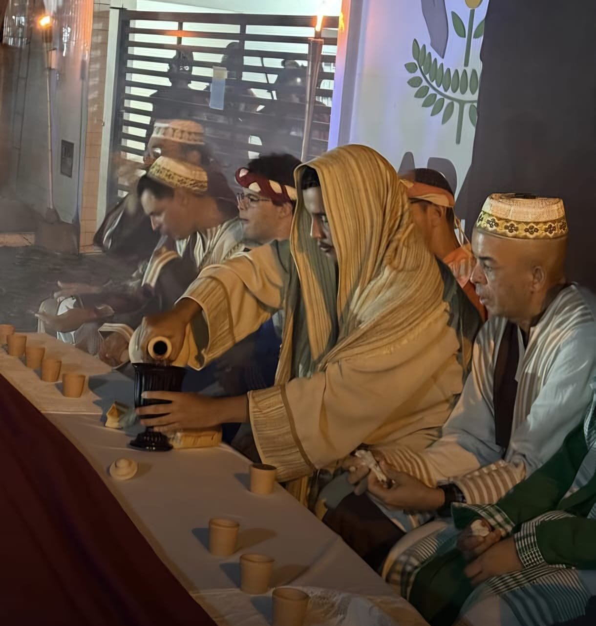 Encenação da Paixão de Cristo em bairro popular de João Pessoa com atores e público envolvido na cena.