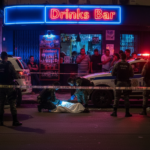 Cena de crime em frente a um bar em João Pessoa após tiroteio.