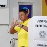 Urna eletrônica durante as eleições suplementares em Cabedelo, com a mão de um eleitor prestes a confirmar o voto.