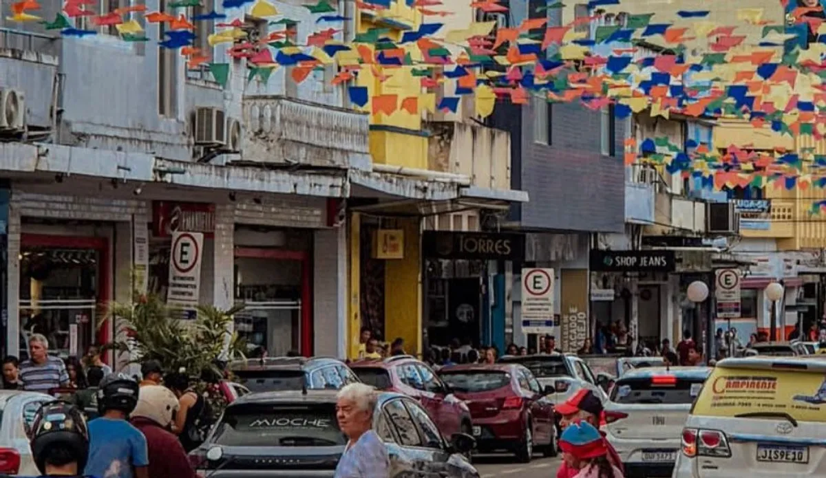 Ruas de comércio em Campina Grande movimentadas durante o São João, com consumidores comprando em lojas decoradas.