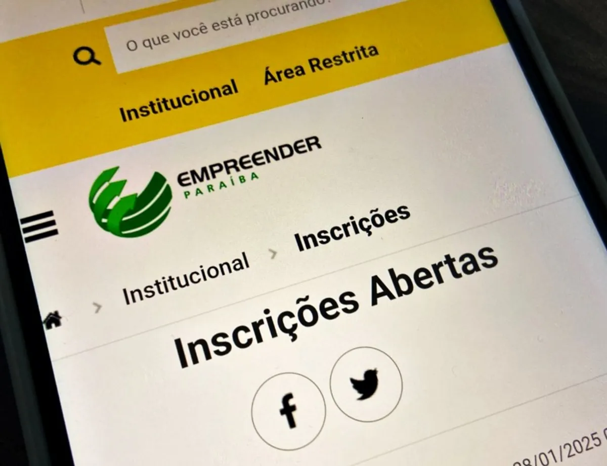 Empreendedor visualizando dados financeiros em um laptop com um sorriso de satisfação, representando o acesso a crédito e o crescimento empresarial.