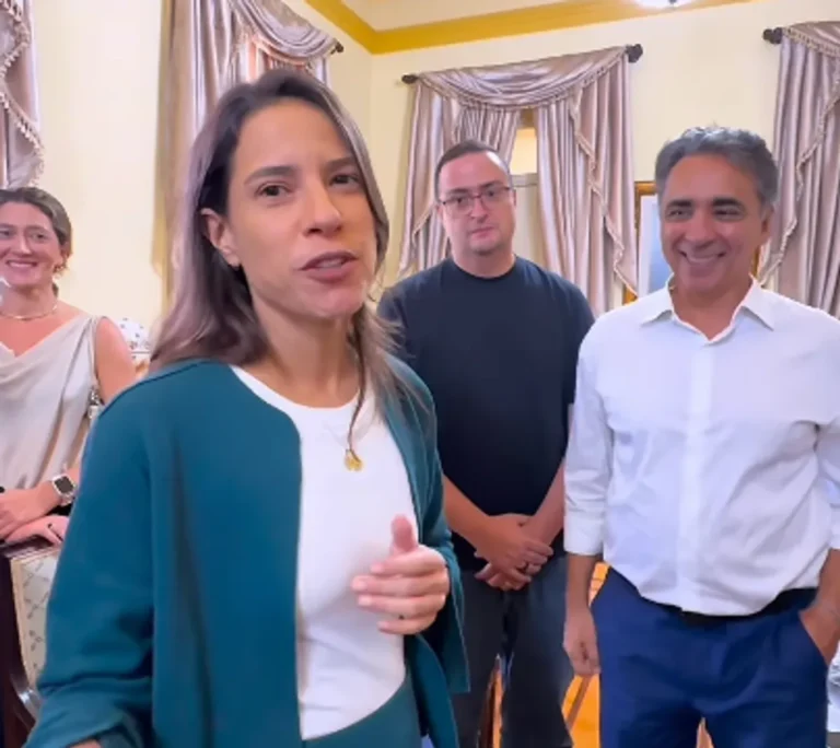 Governadora Raquel Lyra sorrindo em evento junino, com adereços típicos de São João ao fundo