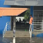 Ruas alagadas em João Pessoa após fortes chuvas, com carros submersos.