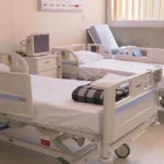 Corredor de hospital em João Pessoa com equipe médica em ação devido à emergência de saúde.