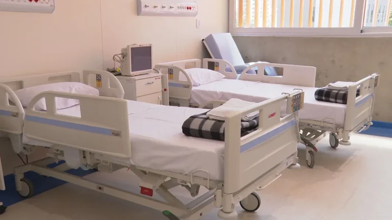 Corredor de hospital em João Pessoa com equipe médica em ação devido à emergência de saúde.