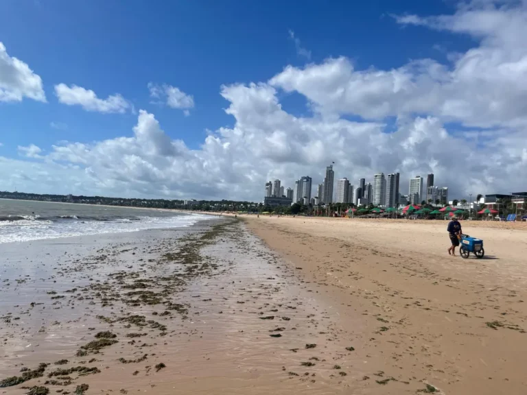 Praia de João Pessoa com a orla urbana e mar azul.
