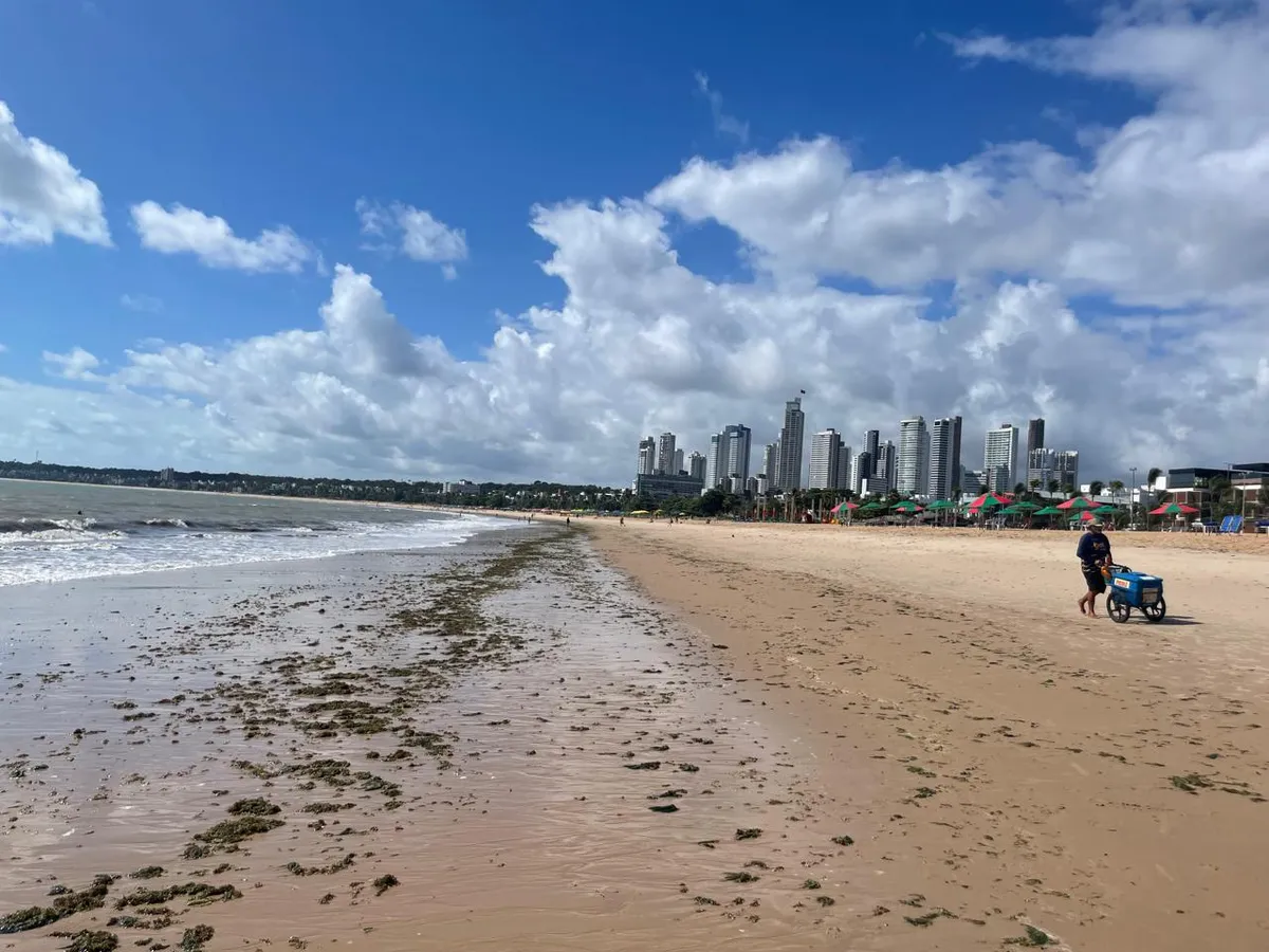 Praia de João Pessoa com a orla urbana e mar azul.