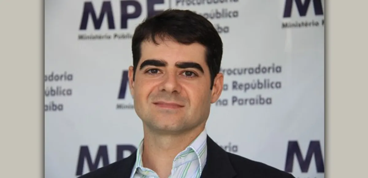 Mãos organizando documentos do MP Eleitoral para as Eleições de 2026 na Paraíba