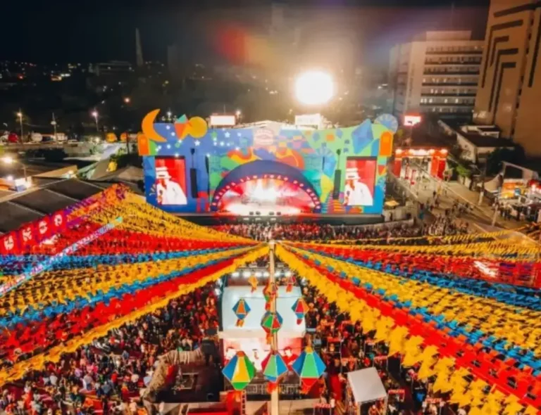 Multidão celebrando o São João de Campina Grande com palco iluminado e artistas locais