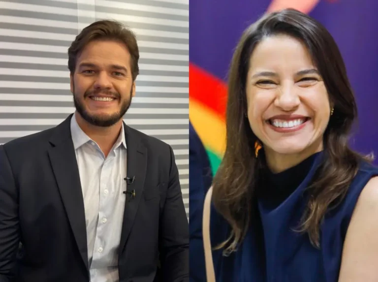 Multidão celebra em um arraial junino durante a noite, com barracas iluminadas e palco ao fundo.