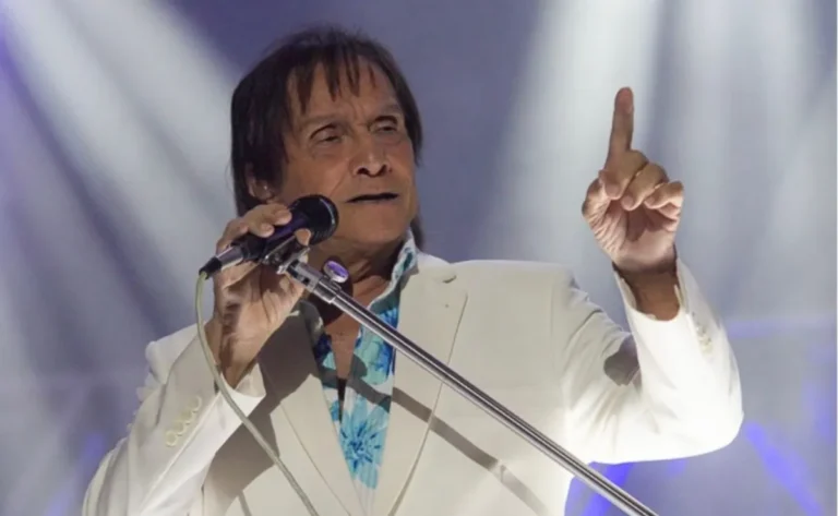 Público festivo em São João do Mundo com Roberto Carlos se apresentando ao fundo.