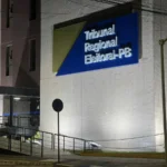 Painel de monitoramento de eleições exibido em tela grande em sala de reunião.