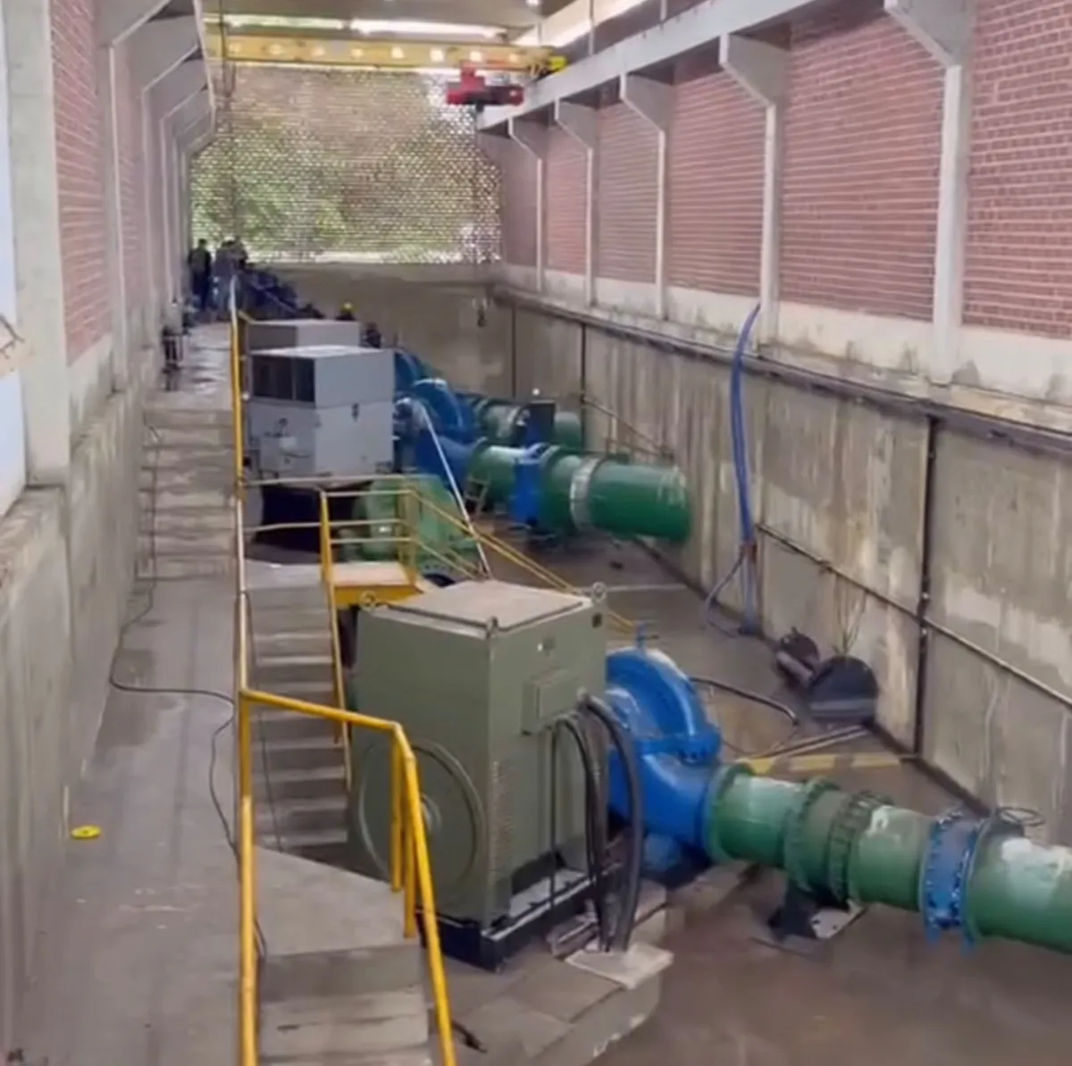 Funcionários da Cagepa inspecionam estação elevatória de água após inundação por chuvas.