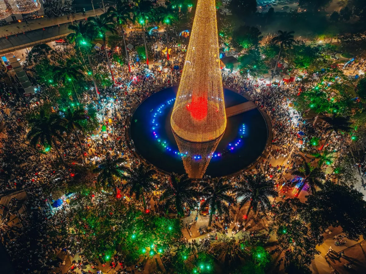 Multidão celebrando e dançando forró em meio a decorações juninas no Maior São João do Mundo de Campina Grande, Paraíba.