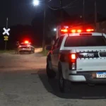 Fachada de residência com portão danificado por tiros em João Pessoa após homicídio.