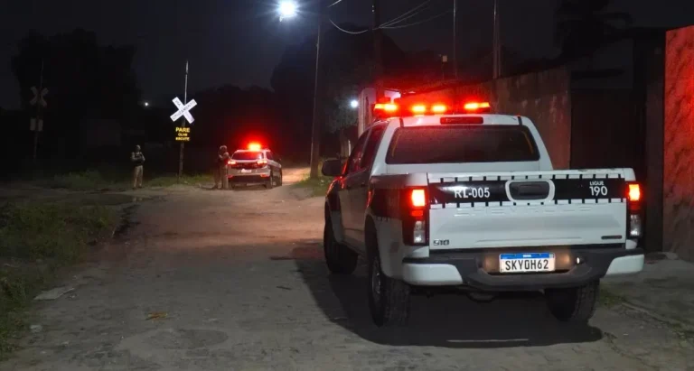 Fachada de residência com portão danificado por tiros em João Pessoa após homicídio.