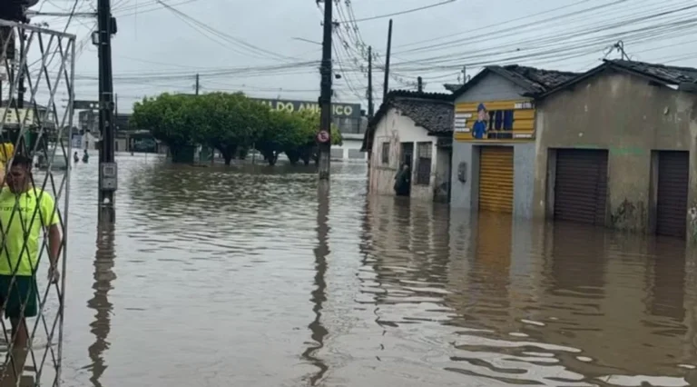 Ruas de João Pessoa inundadas após fortes chuvas, com carros parcialmente submersos.