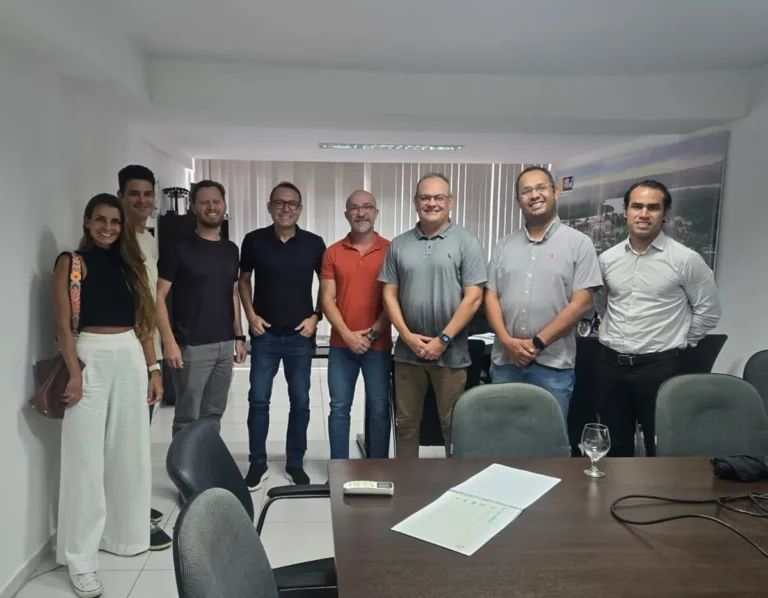 Regata de veleiros Hobie Cat em João Pessoa, com a orla ao fundo.