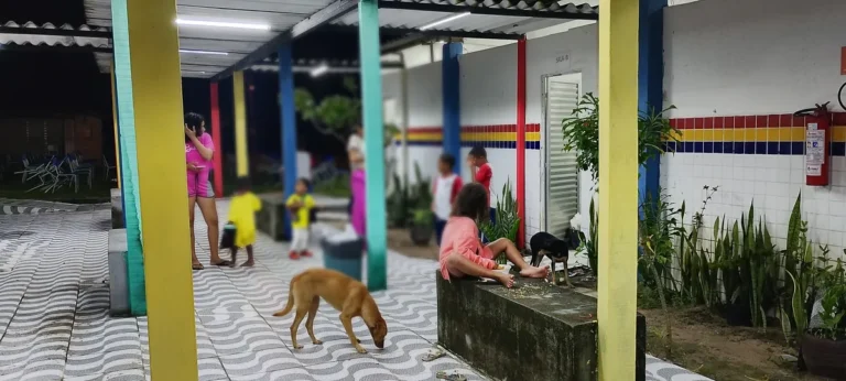 Famílias desabrigadas reunidas na frente de uma escola em João Pessoa após fortes chuvas.