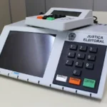 Jovens voluntários mostrando o aplicativo e-Título em seus smartphones.
