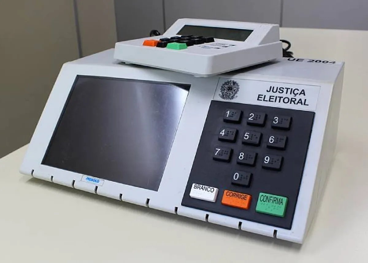 Jovens voluntários mostrando o aplicativo e-Título em seus smartphones.