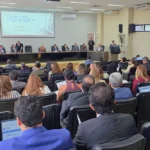 Auditório em João Pessoa com autoridades e participantes durante evento de capacitação eleitoral.