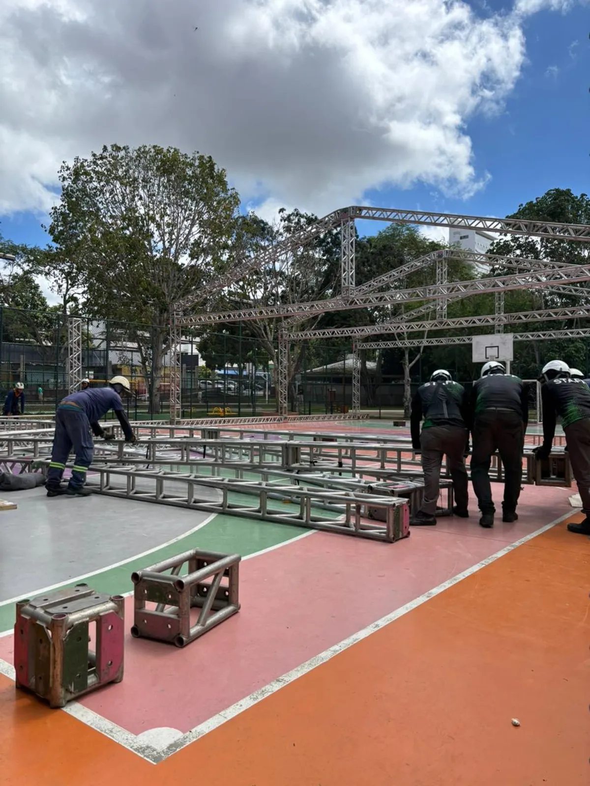 Trabalhadores montando estruturas e pendurando bandeirinhas coloridas no Parque do Povo, Campina Grande, durante a preparação do Maior São João do Mundo.