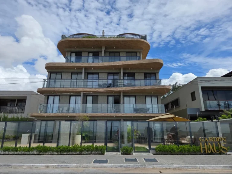 Edifício de flats moderno com vista para o mar ao pôr do sol em João Pessoa.