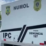 Cena de crime em João Pessoa com polícia e equipes de emergência isolando a área após execução de motorista de aplicativo.