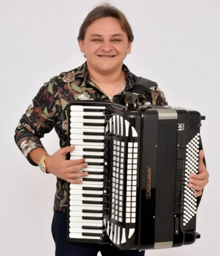Público animado em um grande pré-junino na Paraíba, com palco decorado e fogueira ao fundo.