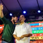 Multidão celebra festa junina na Paraíba com palco iluminado e bandeirinhas.