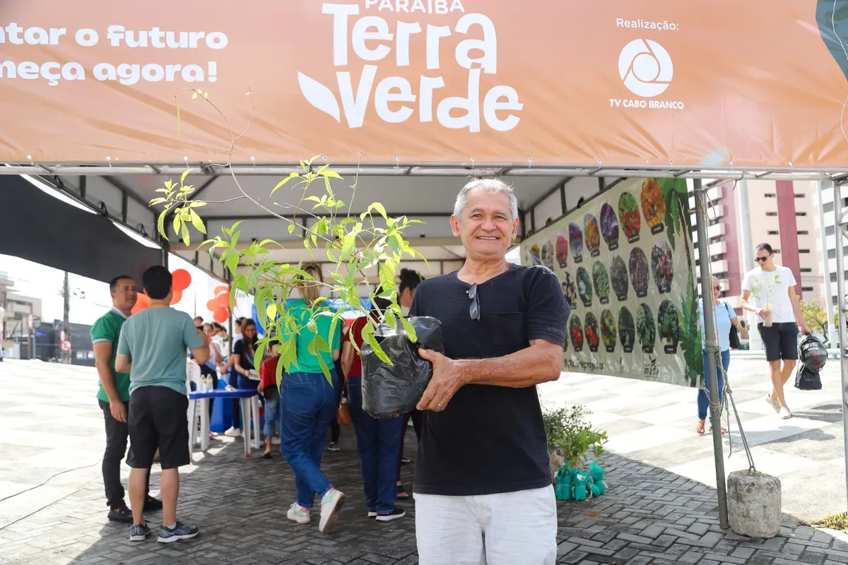 Pessoas participando do projeto Paraíba Terra Verde em João Pessoa, trocando garrafas PET por mudas de plantas.