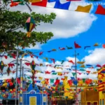 Multidão celebra em festival junino com iluminação festiva no interior do Nordeste.