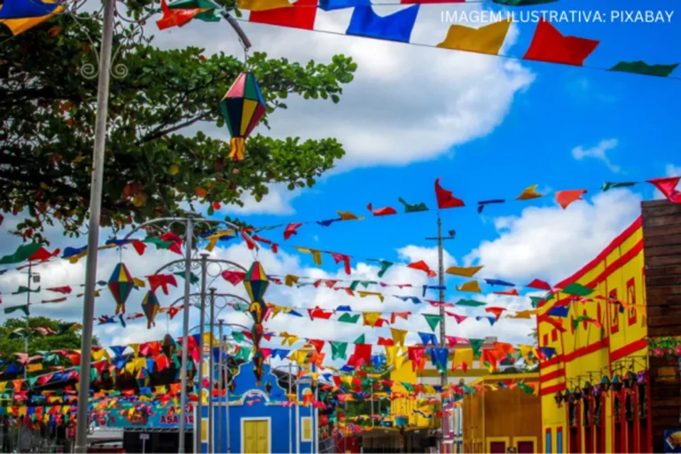 Multidão celebra em festival junino com iluminação festiva no interior do Nordeste.
