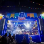 Palco do São João de João Pessoa com público, simbolizando a realocação de recursos para vítimas de chuvas.
