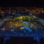 Vista aérea do Terreiro do Forró em Patos durante o São João, com palco iluminado, grande público e estruturas de barracas organizadas, sob o compromisso do TAC.