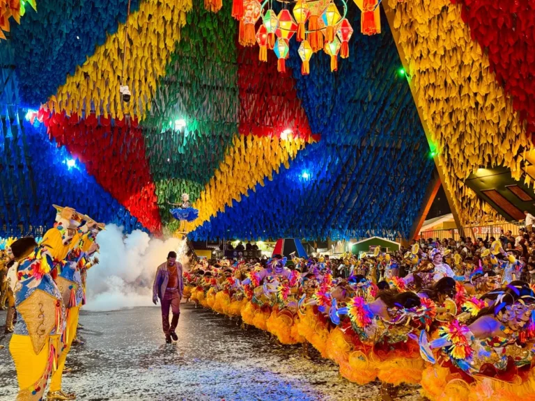 Quadrilha junina performando em Campina Grande durante o São João, com trajes coloridos e iluminação festiva.
