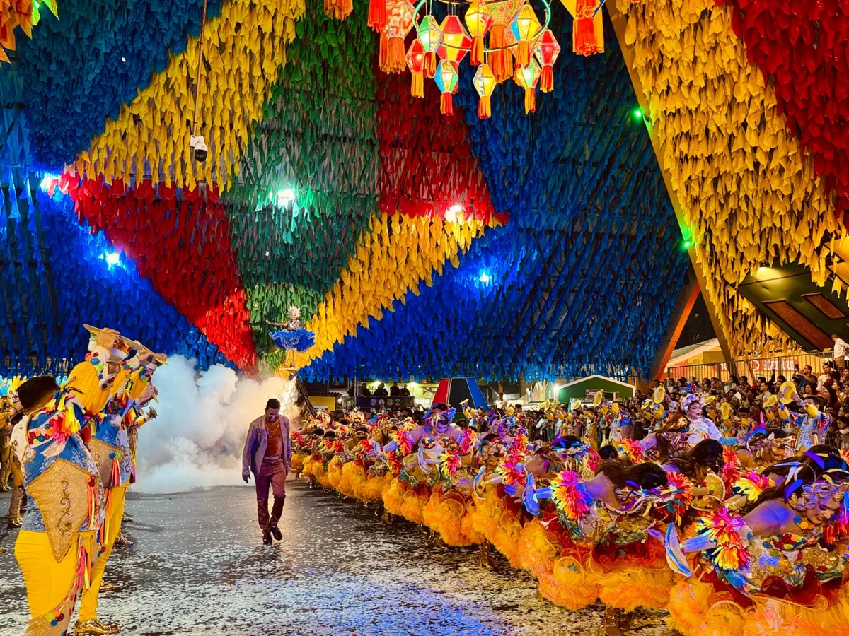 Quadrilha junina performando em Campina Grande durante o São João, com trajes coloridos e iluminação festiva.