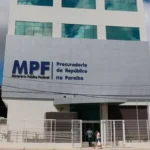 Trabalhadores rurais em frente a usina de açúcar abandonada, simbolizando violações de direitos humanos durante a ditadura militar.