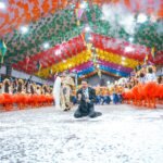 Apresentação vibrante de quadrilha junina durante o Paraíba Junino, com dançarinos em trajes coloridos e público animado.