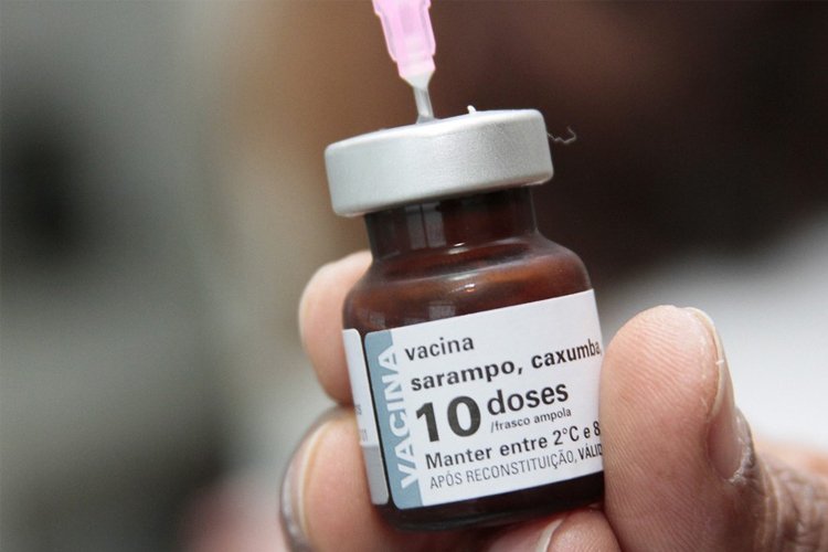 Enfermeira aplicando vacina contra sarampo em criança