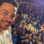 Wesley Safadão se apresenta para uma multidão no Parque do Povo durante o São João de Campina Grande, em palco com iluminação festiva.