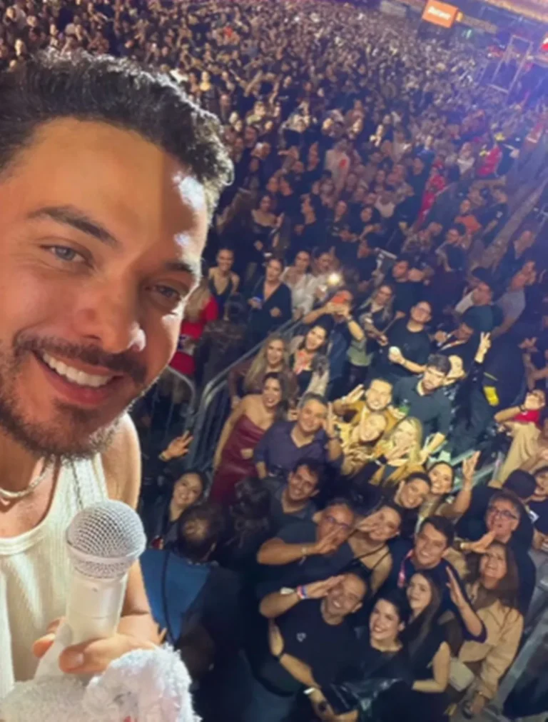 Wesley Safadão se apresenta para uma multidão no Parque do Povo durante o São João de Campina Grande, em palco com iluminação festiva.