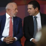 Bastidores de evento político com homens trocando olhares de descontentamento