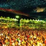 Festa junina na Paraíba com público celebrando e dançando ao som de forró sob iluminação festiva.