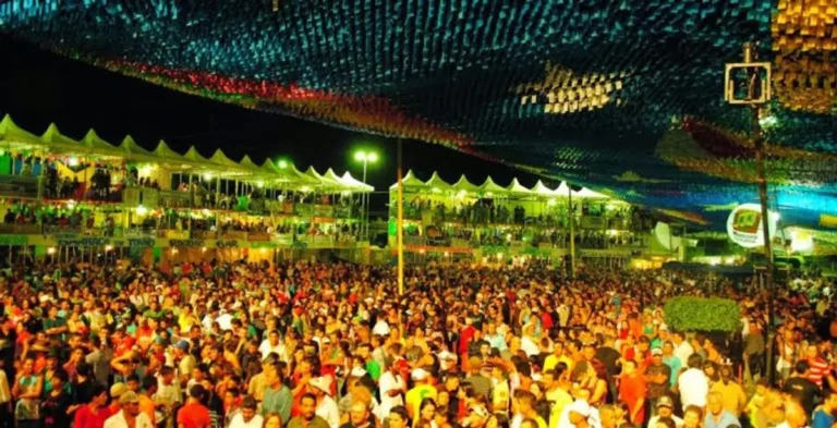 Festa junina na Paraíba com público celebrando e dançando ao som de forró sob iluminação festiva.